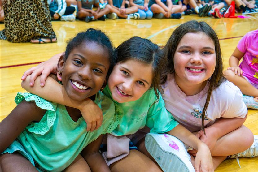 Students smile during an assembly
